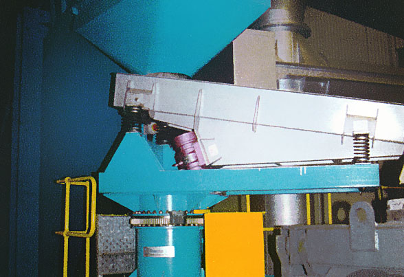 Conveyor discharging onto a slewing vibratory feeder